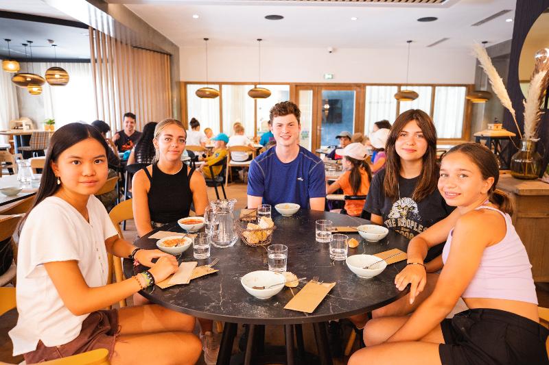 groupe de jeunes à table en colo pour leur petit-déjeuner