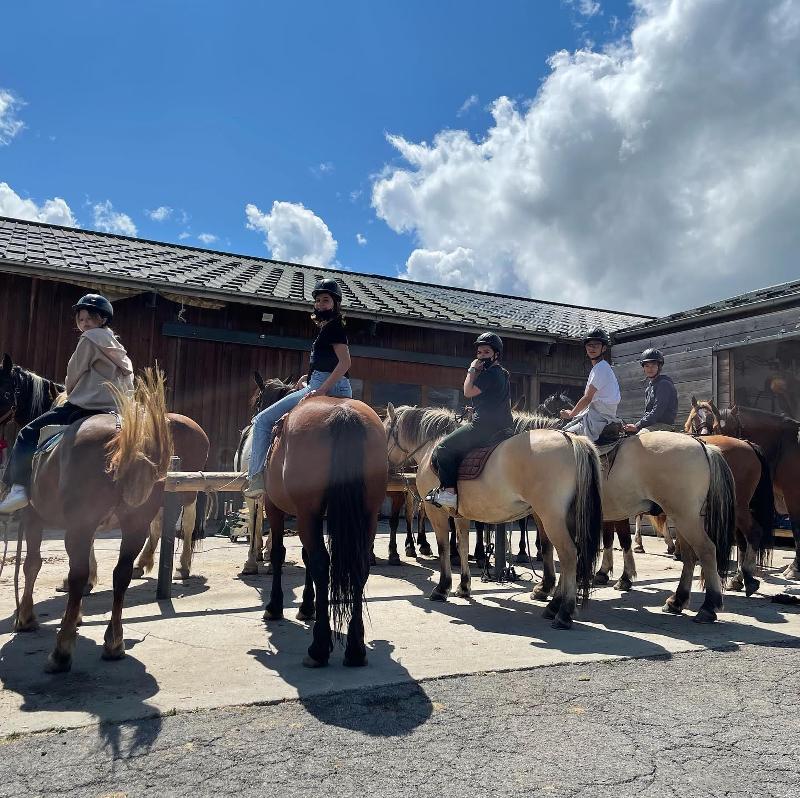 groupe de jeunes qui montent à cheval lors d'une colo à la montagne