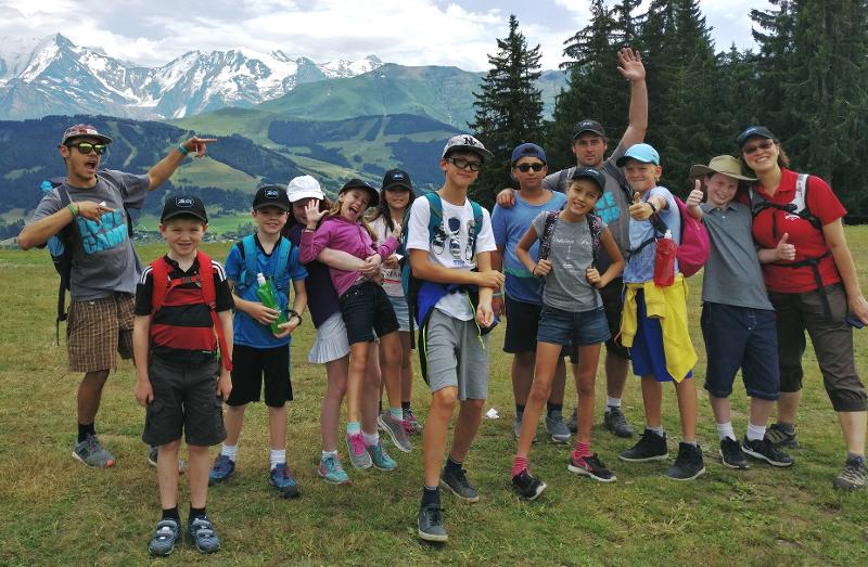 photo de groupe avec les enfants et les animateurs devant des montagnes pendant une colo