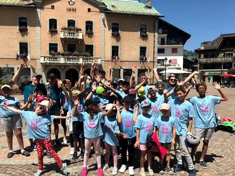enfants avec des t-shirts de la colo qui visitent une ville