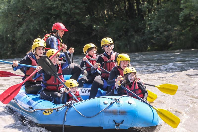 jeunes qui font du rafting en groupe en colo et qui vont être éclaboussés