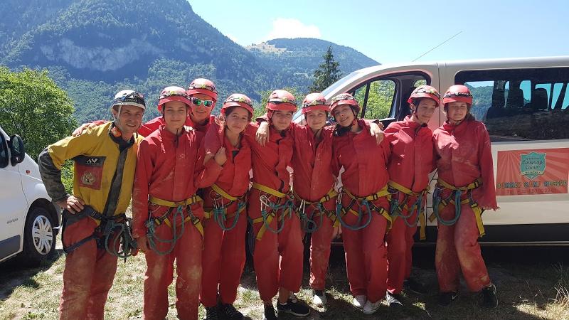 ados avec des combinaisons de spéléologie en colo avec des montagnes en fond