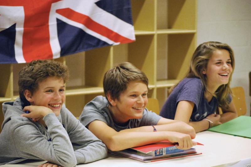 des jeunes qui sourient en apprenant l'anglais