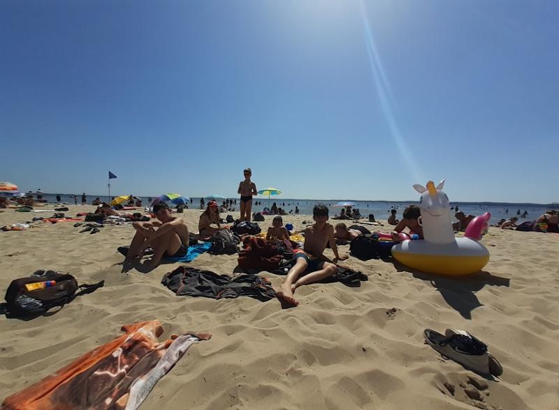 jeunes allongés sur des serviettes à la plage avec une bouée licorne en colo Bordeaux