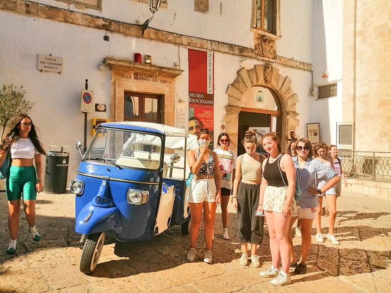 groupe dans la ville à côté d'une voiture en séjour linguistique italien