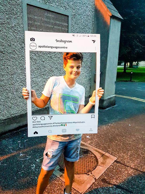 Garçon pris en photo tenant un cadre type publication instagram pour son séjour linguistique irlande