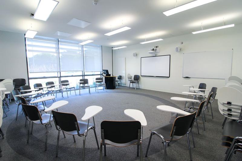 Salle de classe avec des chaises ayant une petite table attachée pour les cours du séjour linguistique irlande