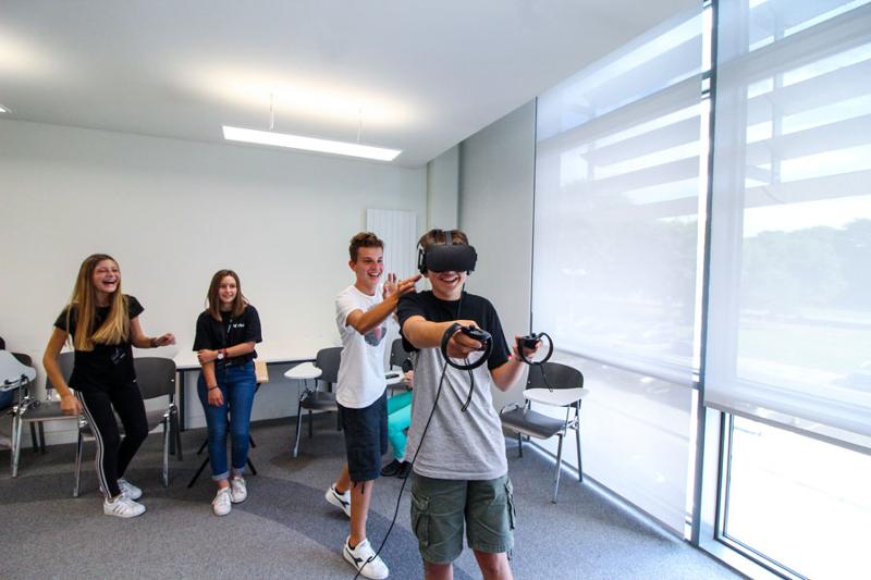 Groupe d'enfants avec un garçon qui porte un casque de réalité virtuelle pendant le séjour linguistique irlande
