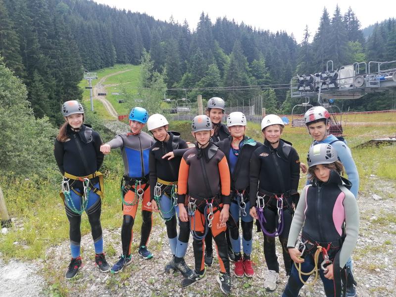groupe de jeunes avec des combinaisons qui vont faire de l'escalade lors d'une colo