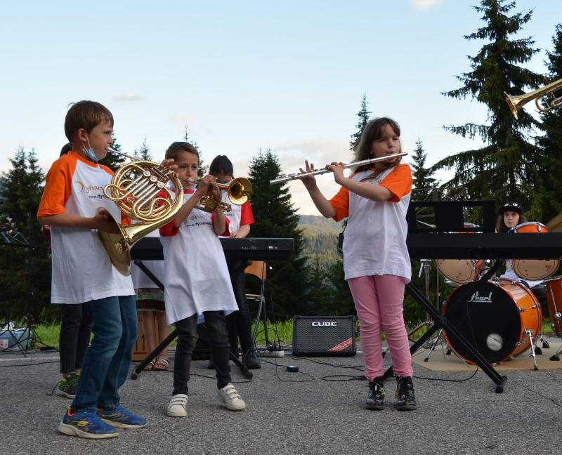 enfants avec les t-shirts du camp qui font de la musique en plein air