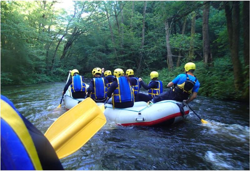 jeunes qui font du rafting en groupe lors d'une colo