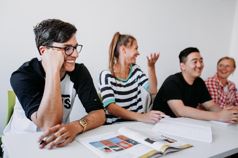 4 participants dans une classe du séjour linguistique espagne avec des manuels et cahiers