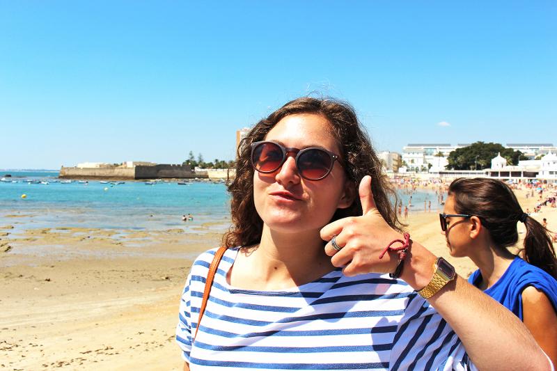 Adolescente avec un pouce levée pendant une sortie du séjour linguistique espagne à la plage 