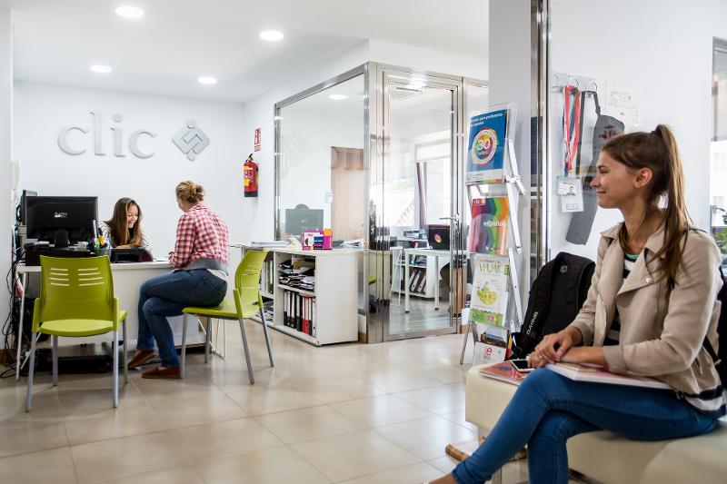 Hall de l'école du séjour linguistique espagne avec des bureaux, des sièges, des brochures