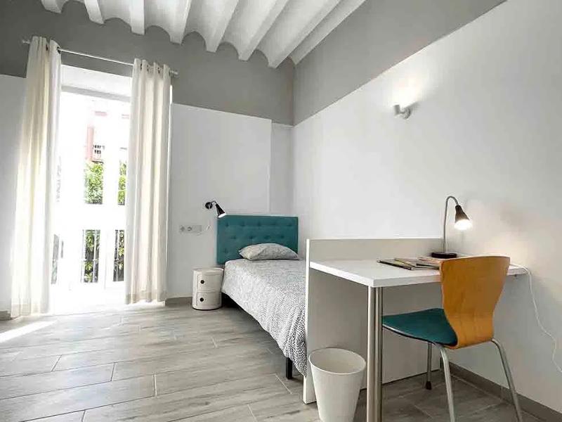 Chambre de la résidence étudiante du séjour linguistique espagne avec un lit individuel et un bureau 