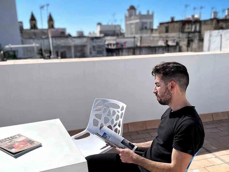 homme en train de lire un magazine sur la terrasse de la résidence étudiante du séjour linguistique espagne 