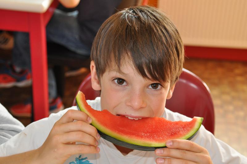 Un enfant mange une pastèque en colonie de vacances Finistere