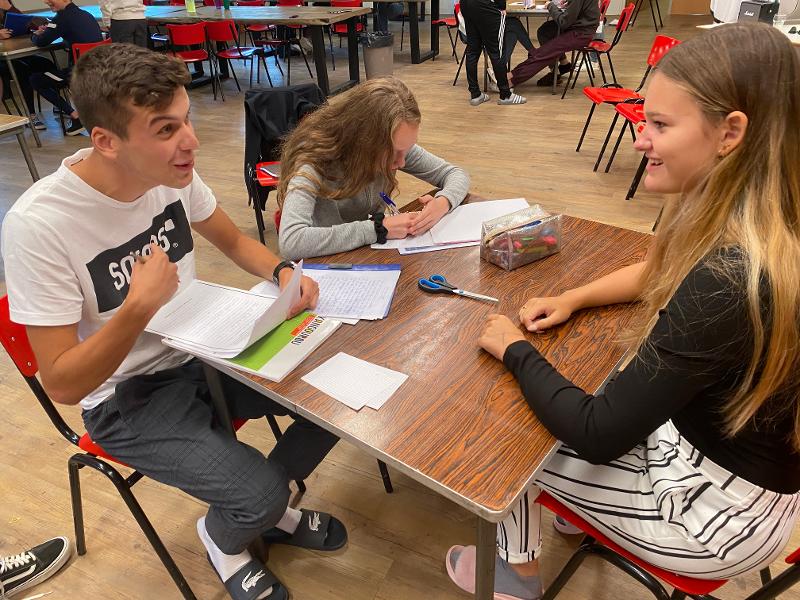 Trois jeunes autour d’une table révisent en séjour linguistique Londres ado