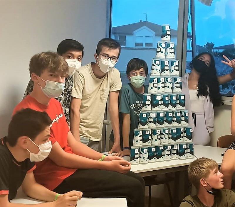 jeunes qui jouent à un jeu avec des verres en carton en séjour linguistique famille