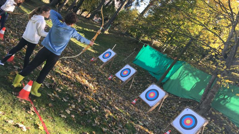 jeunes qui font du tir à l'arc en colonie jeux olympiques