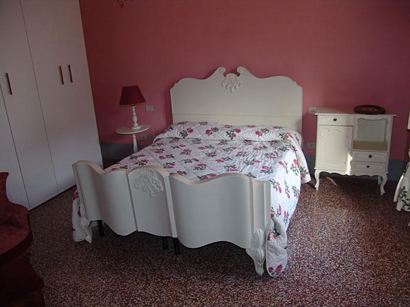 un lit double dans une chambre rose lors du séjour linguistique italien