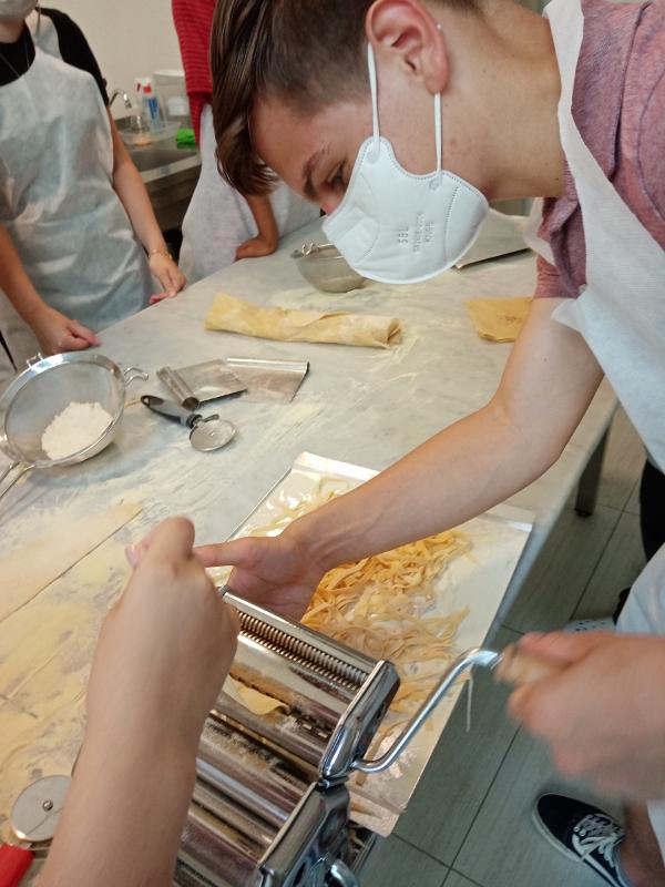 garçon apprenant à faire des pâtes lors de son séjour linguistique en Italie