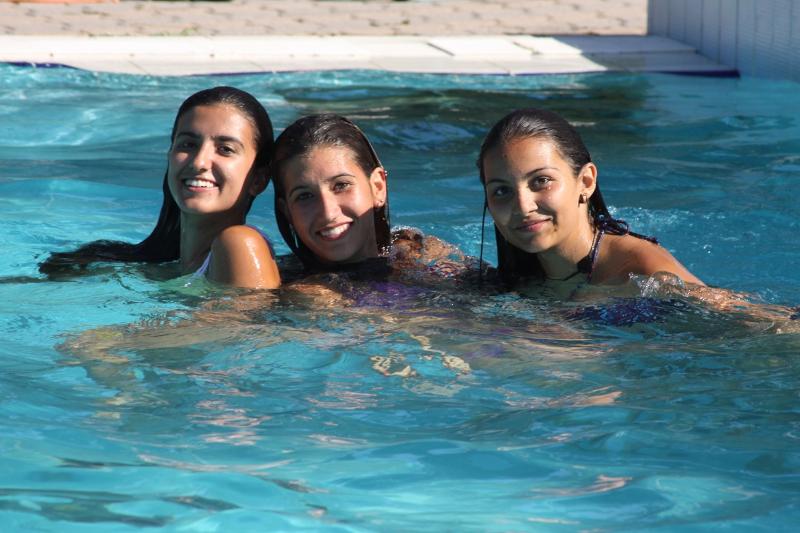 trois jeunes filles se baignant dans une piscine pendant leur séjour linguistique italien