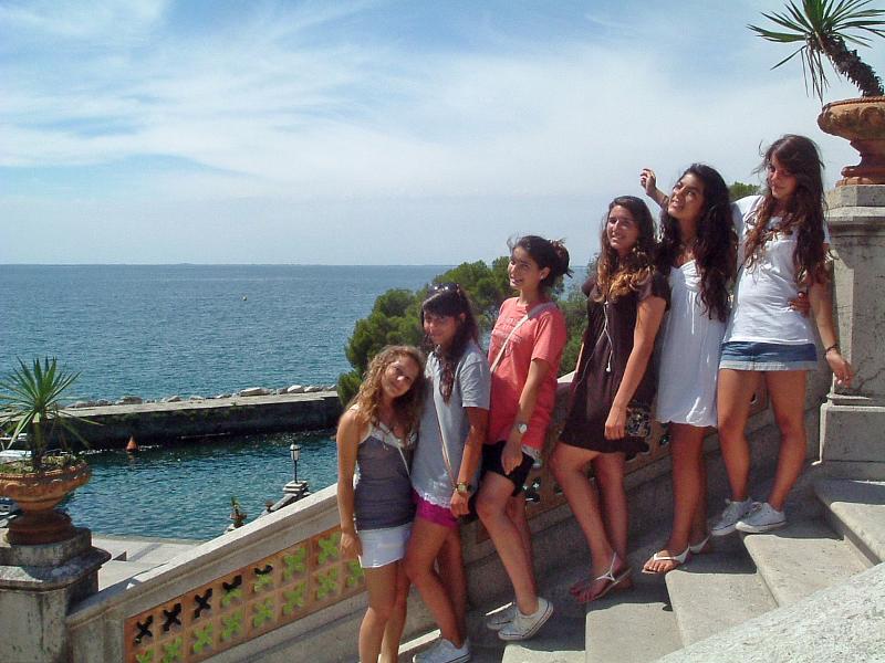 un groupe de filles sur des escaliers en bord de mer pendant leur séjour linguistique italien