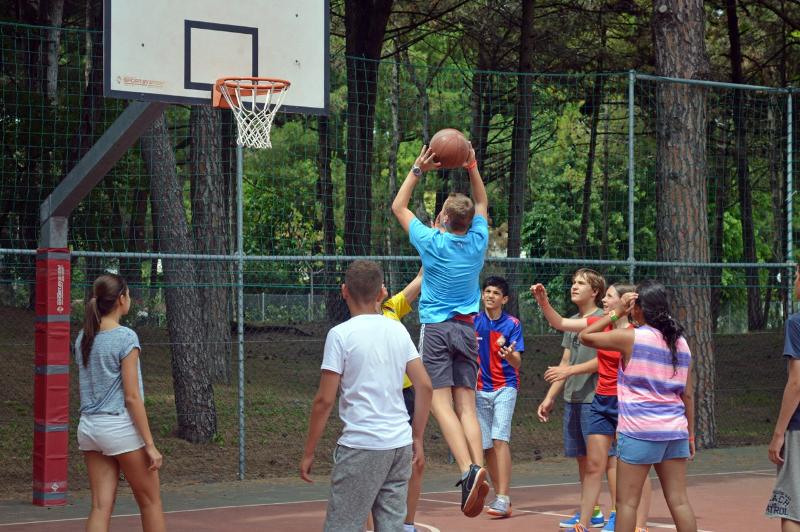 un groupe de jeunes joue au basket pendant leur voyage linguistique italien