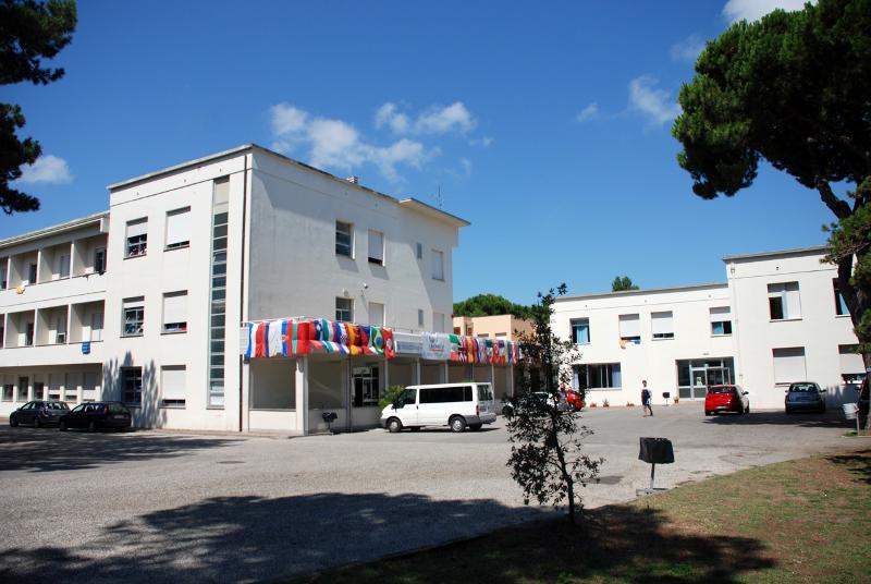 La résidence étudiante du stage linguistique Italie avec drapeaux sur la façade et parking