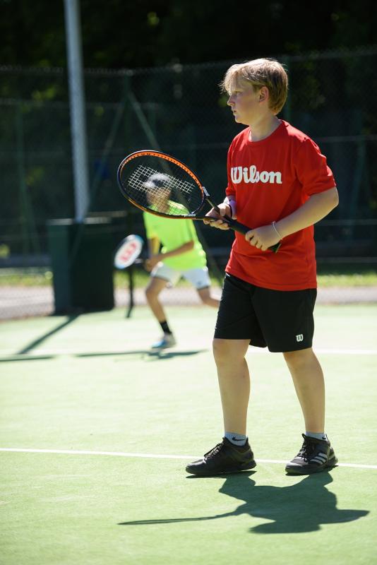 garçon avec une raquette sur une terrain de tennis pendant un séjour linguistique écosse