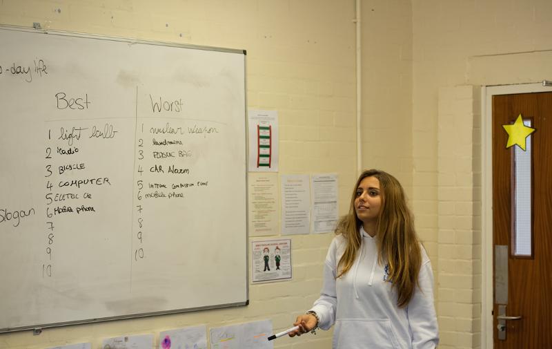 Une ado devant un tableau blanc avec une liste des "best" et "worst" pendant un cours du séjour linguistique écosse