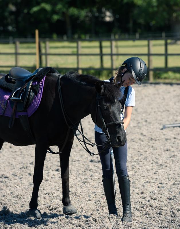 une fille caresse son cheval lors d'une séance équitation du séjour linguistique écosse