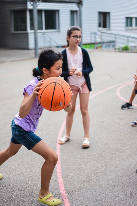 fille avec un ballon de basket en colonie de sport 