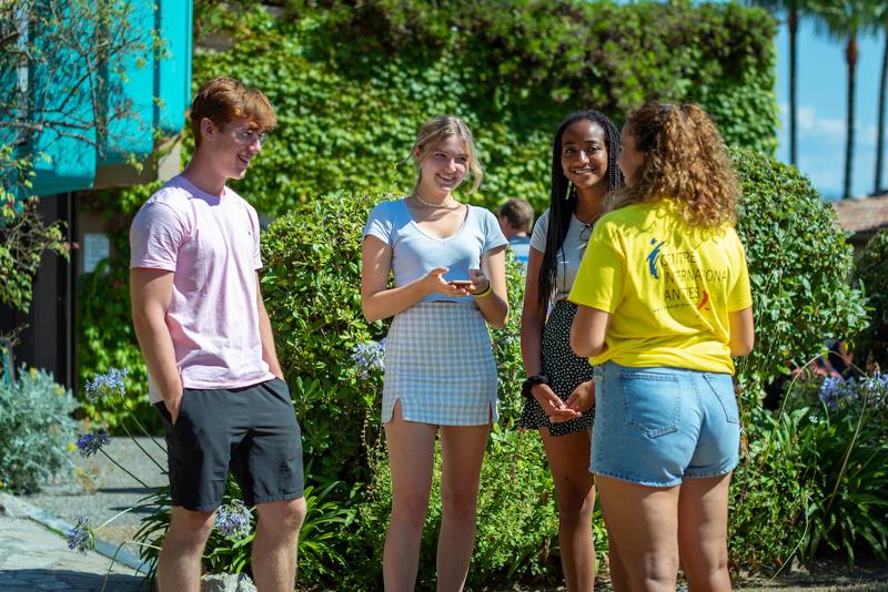 Groupe de 3 jeunes du séjour linguistique discutant dehors avec un animatrice