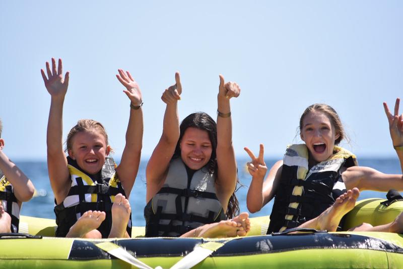 Filles les bras en l'air pendant une activité nautique du séjour linguistique