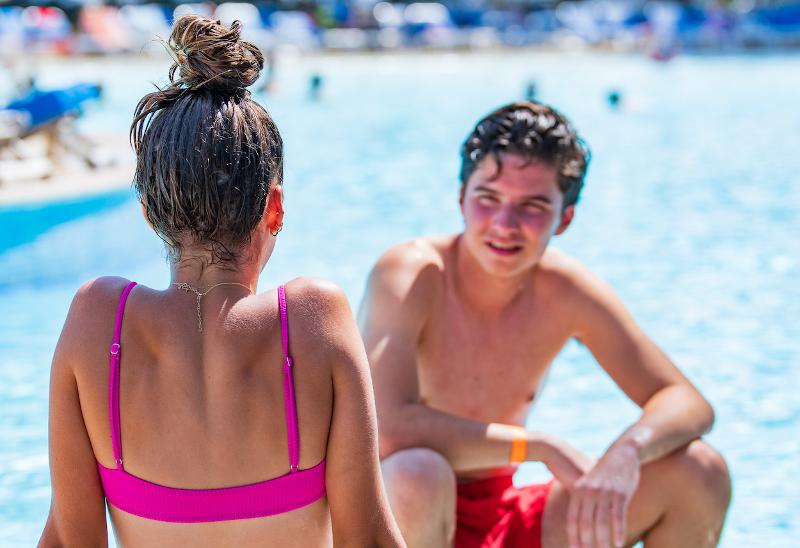1 fille et 1 garçon au bord de la piscine du séjour linguistique