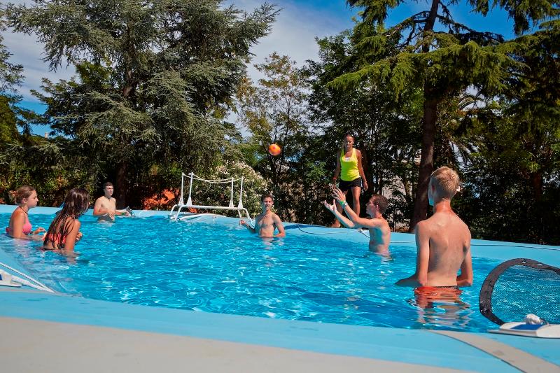 Jeunes jouant avec un ballon dans la piscine du séjour linguistique