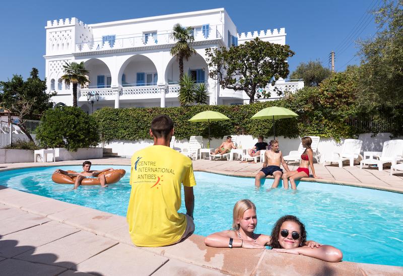 Jeunes dans une piscine du séjour linguistique surveillés par un moniteur