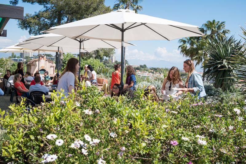 Jardins avec des tables et des parasols pendant le séjour linguistique