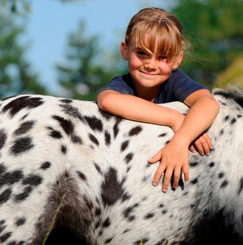 fille qui fait un calin en colonie poney