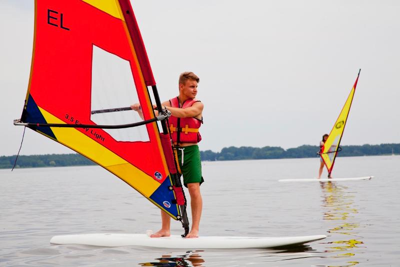 Garçon debout sur une planche à voile pendant son sejour linguistique allemand