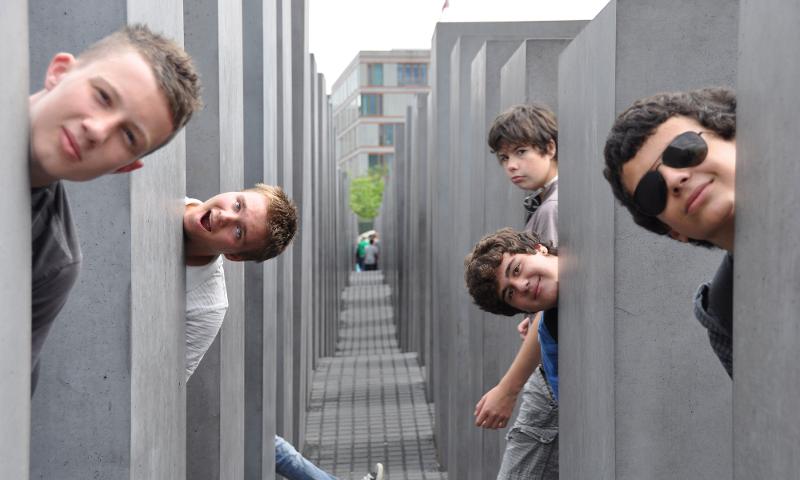 garçon entre les statues du mémorial aux juifs assassinés lors d'une visite de Berlin du sejour linguistique allemand