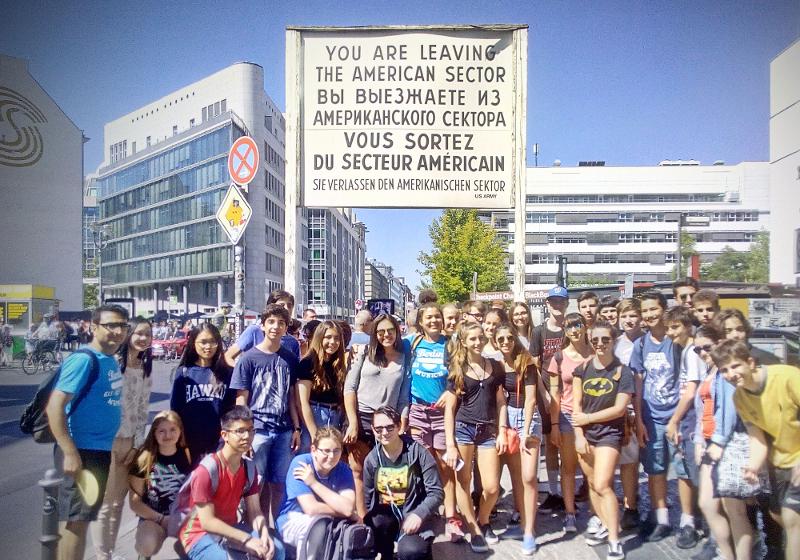 Photo de groupe du sejour linguistique allemand devant le panneau du checkpoint Charlie à Berlin 