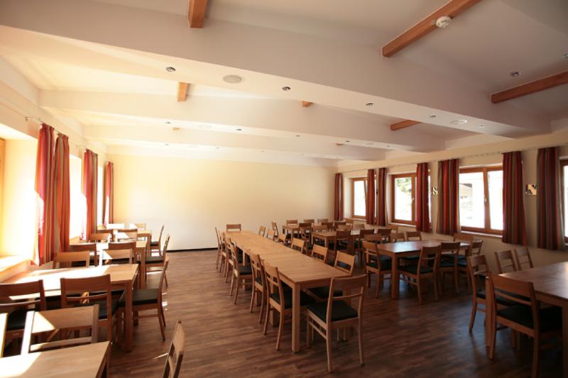 Salle de repas du sejour linguistique allemand avec des grandes tables et chaises en bois 