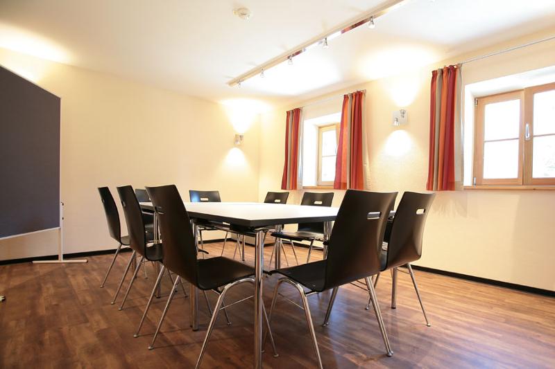 salle de classe avec une grande table et des chaises autour ainsi qu'un tableau pour le sejour linguistique allemand 