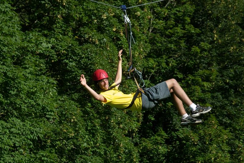 garçon sur une tyrolienne au milieu des arbres pour le sejour linguistique allemand 