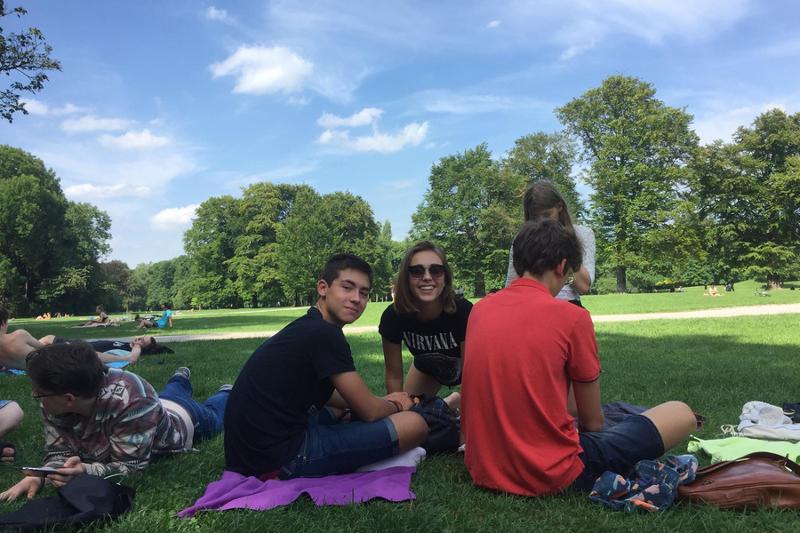 jeunes en train de se détendre sur une grande pelouse d'un parc pendant leur sejour linguistique allemand 