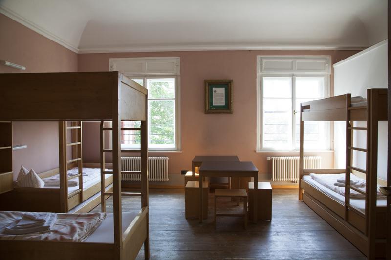 Chambre du sejour linguistique allemand avec 3 lits superposé et des tables au milieu de la pièce 