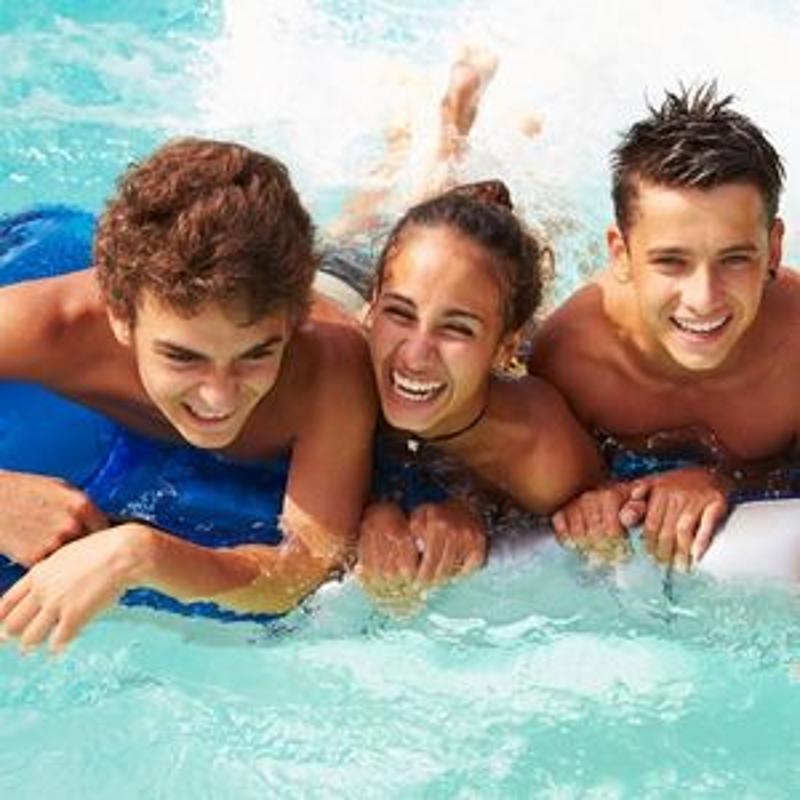 trois jeunes ados dans l'eau sur des bouées gonflables 
